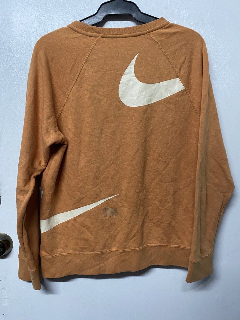 Nike Big Swoosh Sweatshirt XL (Category: Coats, Jackets and Outerwear) located in Quezon City. Submitted by thriftkitaph (Listing ID 1428397238, Image 2). Description: Nike sweatshirt in a burnt orange color with a large white swoosh design. Features the Nike logo on the tag and the word "registered" and "trademark" printed on the sleeve. The size is XL. Made in China..