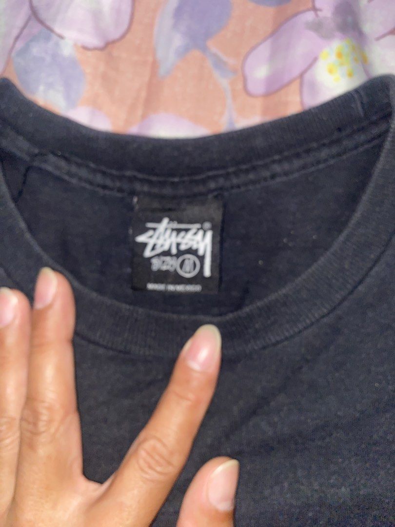Stussy 8 Ball Graphic Tee (Category: Tshirts & Polo Shirts ) located in Batangas. Submitted by aidenbotchog (Listing ID 1428303188, Image 3). Description: Black Stussy t-shirt featuring the iconic 8 ball graphic on the back. The shirt has a crew neck and short sleeves. The tag indicates it is made of 100% cotton. The size is M. The shirt has the Stussy logo on the front. L29 W19.