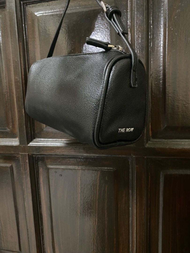 The Row 90’s Mini Bag (Category: Luxury Bags & Wallets) located in Manila. Submitted by haveago0dthrift (Listing ID 1428383863, Image 1). Description: -Black mini bag from The Row. -The bag has a cylindrical shape. -The Row logo is visible on the side. .