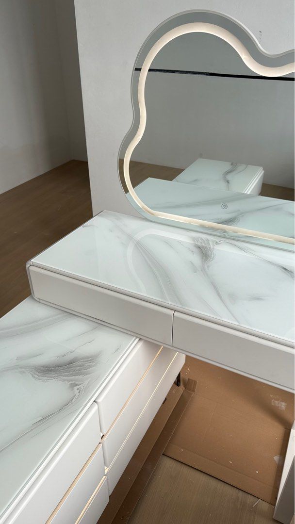 Vanity table / Dressing table (Category: Tables & Sets) located in Petaling Jaya. Submitted by fawahinshirah (Listing ID 1428353524, Image 2). Description: Bought for RM 1.5k selling at RM600 SELF PICKUP AT BANDAR SRI DAMANSARA LALAMOVE IS AT ADDITIONAL COST - Cloud-shaped LED mirror - White marble-look vanity table - Two drawers for storage - Matching table with 6 drawer storage - Touch sensor for LED lights (3 changeble colours) LED lights also