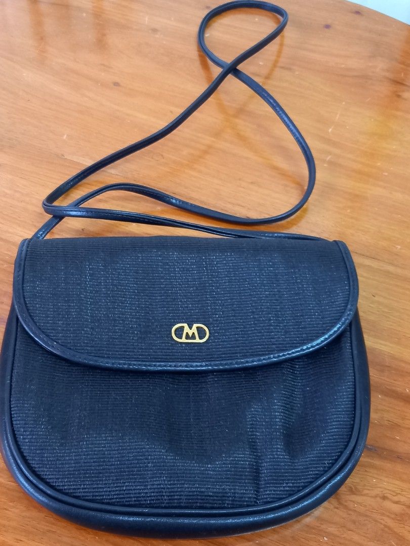 Vintage Black Leather Crossbody Bag (Category: Cross-body Bags) located in Tuguegarao City. Submitted by zenphoenix-7ad615 (Listing ID 1428293301, Image 2). Description: Classic black crossbody bag. Features a flap closure with a gold-toned logo. The bag has a long, thin strap for shoulder or crossbody wear. Interior includes a zippered pocket and is marked "Genuine Leather Made in Italy". A timeless accessory for everyday use..