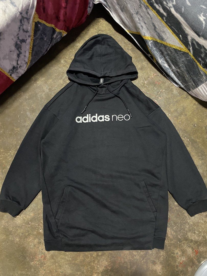 Adidas Neo Hoodie Black (Category: Hoodies) located in Malabon City. Submitted by yivsthrift (Listing ID 1428547832, Image 1). Description: Black Adidas Neo hoodie. Features a hood with drawstrings and a kangaroo pocket. The Adidas Neo logo is printed on the front. The size is A/XL, made in China. The care label is visible, with washing instructions. The hoodie is black. Dimes L31 x W23 inches.