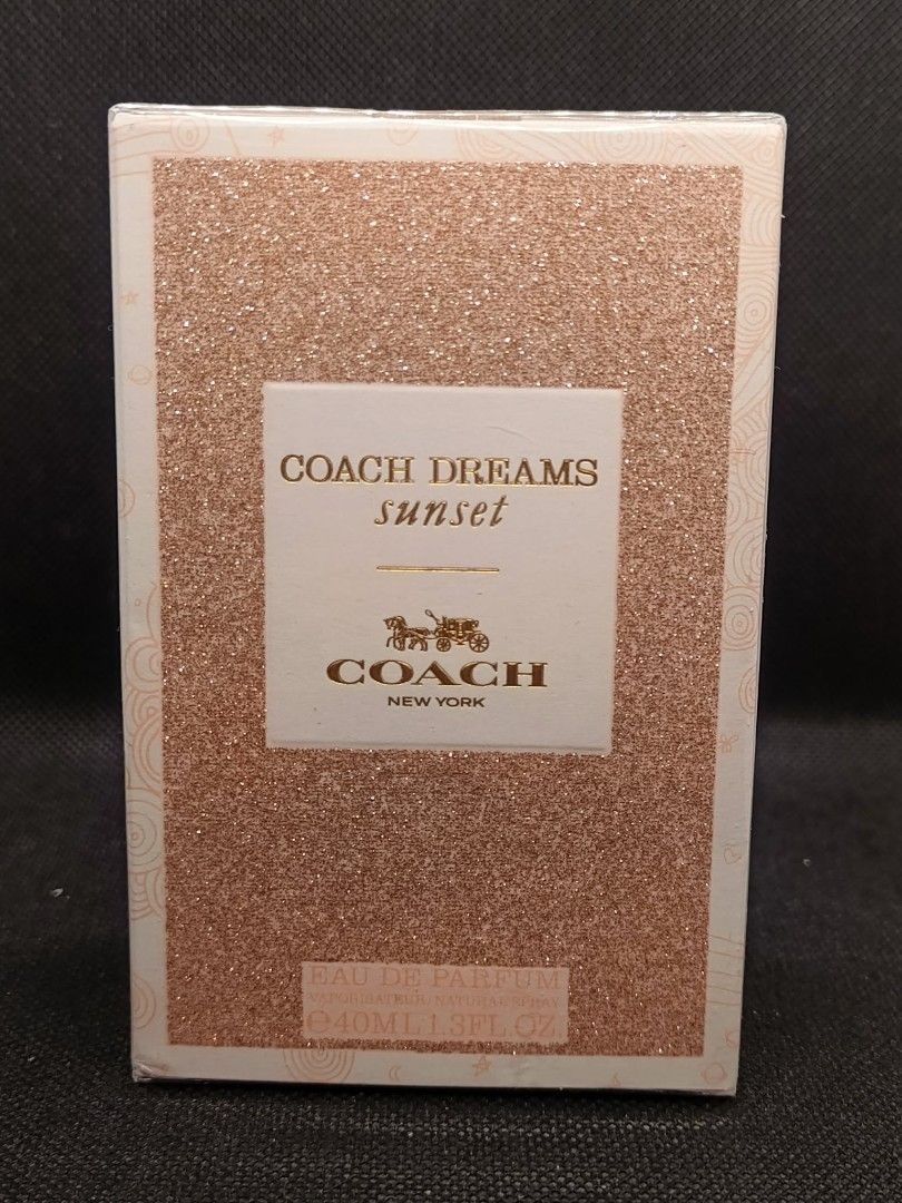 Coach Dreams Sunset Eau de Parfum 40ml (Category: Fragrance & Deodorants) located in Kawit. Submitted by chapter.leaf14 (Listing ID 1428599415, Image 1). Description: Coach Dreams Sunset Eau de Parfum. The box contains a 40ml bottle. The fragrance is from the Coach New York brand. The box has a glittery, pinkish-orange design with the Coach logo and product name. The box is sealed..