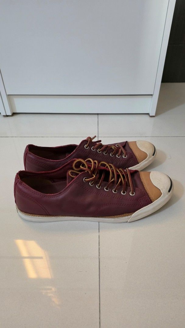CONVERSE - Jack Purcell Leather Sneakers (RARELY USED) (Category: Sneakers) located in Quezon City. Submitted by mikeepreloveditems (Listing ID 1428538130, Image 1). Description: These Jack Purcell sneakers feature a burgundy leather upper with a contrasting white toe cap and sole. They have a lace-up closure with brown laces. The design is classic and versatile, suitable for various casual outfits..