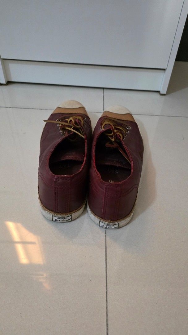CONVERSE - Jack Purcell Leather Sneakers (RARELY USED) (Category: Sneakers) located in Quezon City. Submitted by mikeepreloveditems (Listing ID 1428538130, Image 2). Description: These Jack Purcell sneakers feature a burgundy leather upper with a contrasting white toe cap and sole. They have a lace-up closure with brown laces. The design is classic and versatile, suitable for various casual outfits..