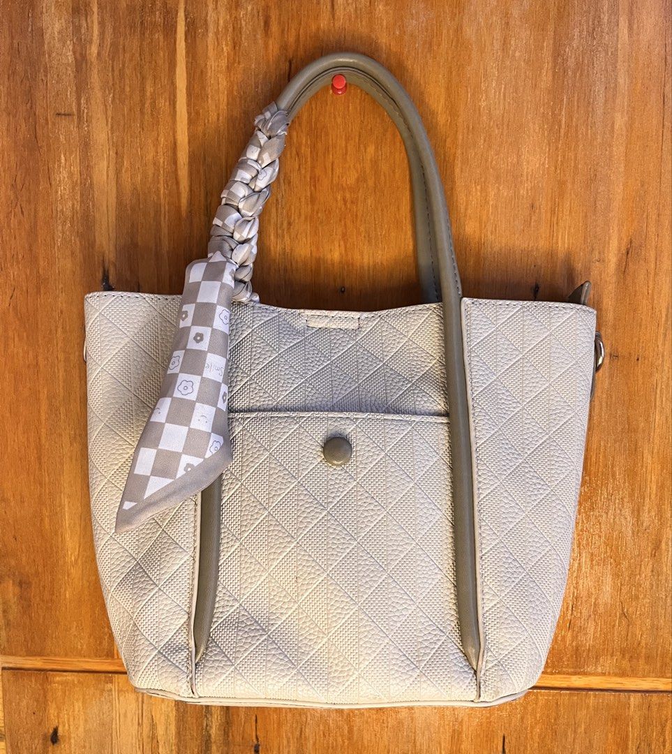 Cream Quilted Handbag with Scarf (Category: Luxury Bags & Wallets) located in Marikina City. Submitted by fvasquez_ (Listing ID 1428496081, Image 1). Description: Cream-colored handbag with a quilted pattern. Features a front pocket with a button closure and a matching scarf tied to the handle. The bag has a structured shape with a top handle and a neutral color scheme..