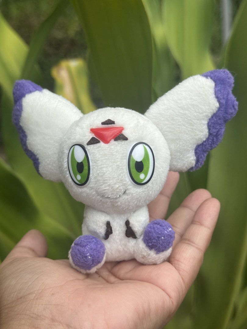 Digimon Patamon Plush Toy (Category: Plushies & Soft Toys) located in Antipolo. Submitted by bhabiegraciefashionlab (Listing ID 1428490706, Image 1). Description: Adorable Patamon plush toy. Features white body with purple accents on the ears and feet. It has green eyes and a red triangle on its forehead. The tag indicates it was made by Bandai in 2001. A cute collectible for Digimon fans..