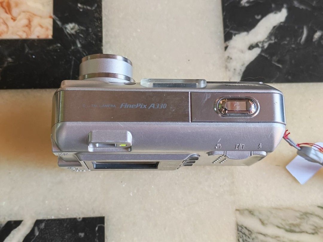 Fujifilm FinePix A330 Digital Camera (Category: Cameras) located in Manila. Submitted by jonrick.co (Listing ID 1428514334, Image 2). Description: Fujifilm FinePix A330 digital camera. It has a 3.2 megapixel resolution. The camera is silver and has a built-in flash. It includes a lens and a power cable. The camera's model name is visible on the top of the camera. execellent working condition slight issue pag oudoor minsan over exposed 16mb xd car