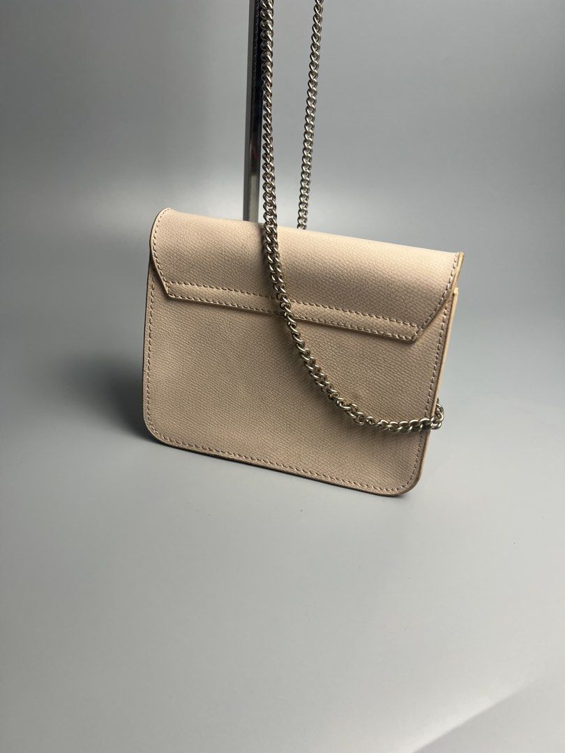Furla Mini Crossbody Bag (Category: Luxury Bags & Wallets) located in Manila. Submitted by reclaim.13 (Listing ID 1428490751, Image 2). Description: - IN GREAT CONDITION - FOR WOMENS - VERY UNIQUE STYLE - ISSUE IS INDICATE ON THE PICTURES SLIDE Furla mini crossbody bag features a light pink exterior with a chain strap. It has a flap closure with the Furla logo. The interior has a small pocket. The bag is marked "Made in Italy". Includes a small l