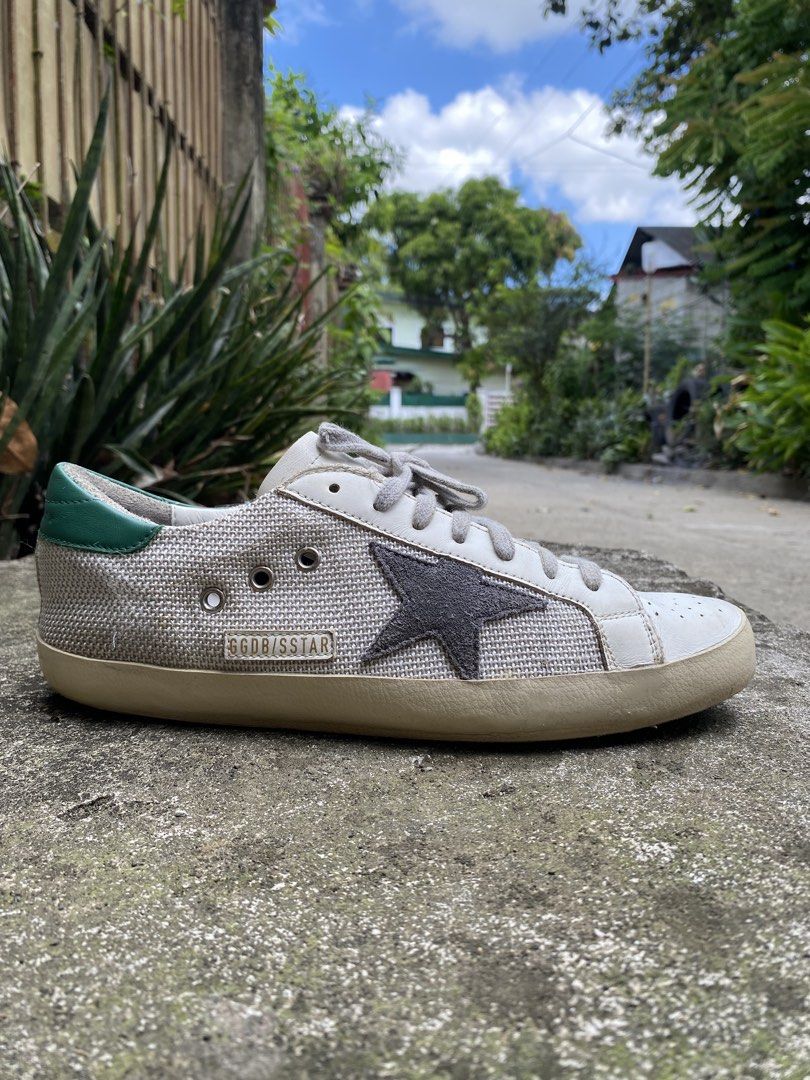 Golden Goose Superstar Sneakers (Category: Sneakers) located in Iloilo. Submitted by resellmpg (Listing ID 1428436175, Image 2). Description: Golden Goose Superstar sneakers in white, gray, and green. Features a gray star on the side and a mesh upper. The heel tab is green leather. The sole is off-white. The laces are gray. The sneakers have a worn look..