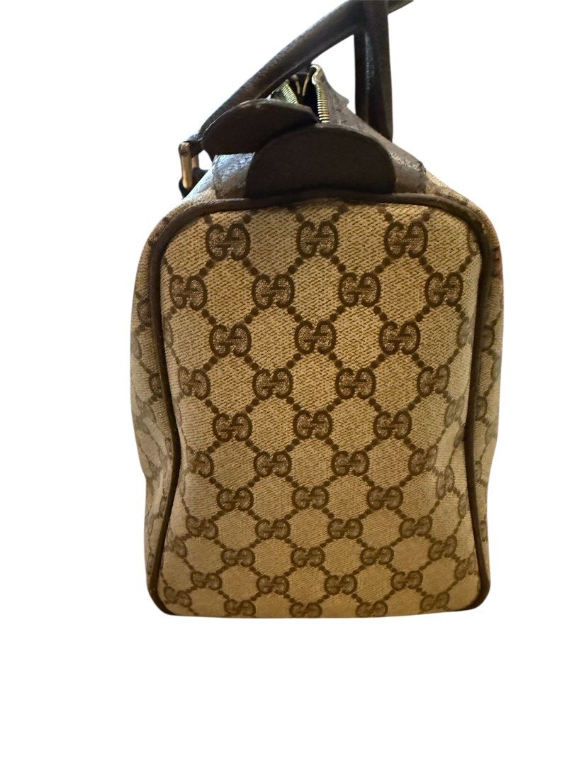 Gucci Boston Bag with Cherry line (Category: Luxury Bags & Wallets) located in Mandaluyong City. Submitted by autumndei (Listing ID 1428502088, Image 3). Description: Classic Gucci Boston bag featuring the iconic GG monogram canvas. It has a brown leather trim, handles, and a signature green and red web stripe. The bag has a top zipper closure and a small interior pocket. The bag has a structured shape and a timeless design. Vintage Changed inter