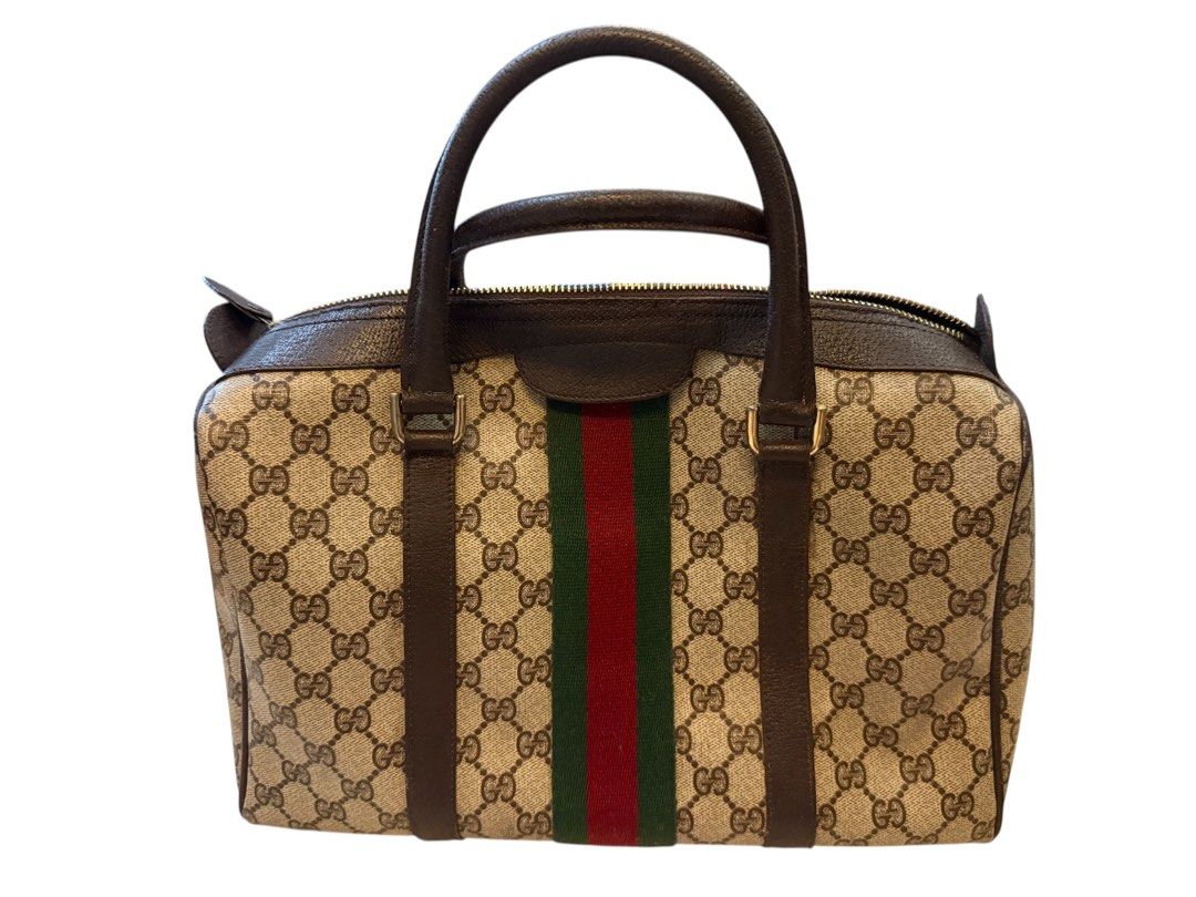 Gucci Boston Bag with Cherry line (Category: Luxury Bags & Wallets) located in Mandaluyong City. Submitted by autumndei (Listing ID 1428502088, Image 2). Description: Classic Gucci Boston bag featuring the iconic GG monogram canvas. It has a brown leather trim, handles, and a signature green and red web stripe. The bag has a top zipper closure and a small interior pocket. The bag has a structured shape and a timeless design. Vintage Changed inter