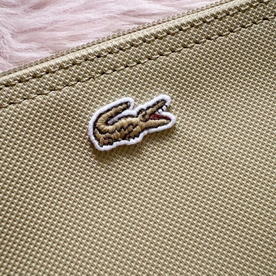 Lacoste Clutch in Beige/Brindille (Category: Purses & Pouches) located in Caloocan City. Submitted by _yownice (Listing ID 1428573830, Image 2). Description: Lacoste Clutch in Beige/Brindille 100% original, on hand ph and ready to ship Feature: - Lacoste branded zipper slider - Embroidered green Crocodile branding - Exterior in PVC Specifications: - Dimensions 8.2 x 4.7 x .4 in - Outside: Pvc (100%).