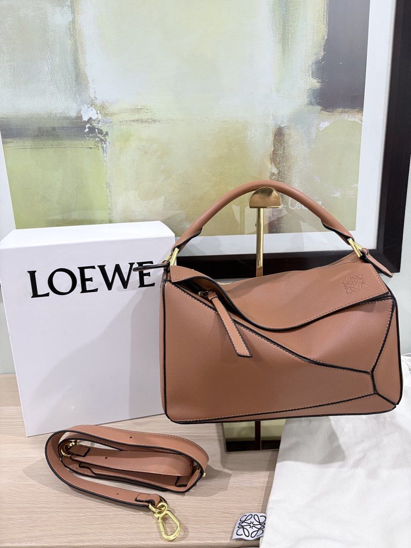 Loewe medium puzzle bag in tan complete inclusions (Category: Luxury Bags & Wallets) located in Quezon City. Submitted by herluxe_official (Listing ID 1428445961, Image 1). Description: Loewe Medium Puzzle Bag Bought from Hongkong. Dimensions: Medium: (28/29 x 19 x 14 cm) ✈️WE SHIP NATIONWIDE ✅SAME DAY DISPATCH Complete inclusions Dustbag, paperbag, cards and box .