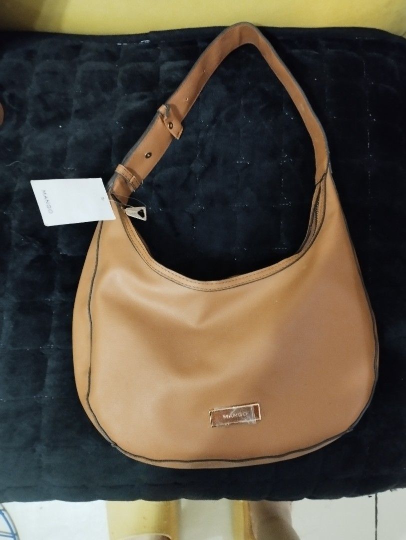 Mango Shoulder Bag Bundle sale with long Kipling wallet (Category: Shoulder Bags) located in Caloocan City. Submitted by myprelovedbutlovedshop (Listing ID 1428503980, Image 2). Description: Mango shoulder bag in a warm brown color. Features a single shoulder strap and a zip closure. The interior is black. The bag has a Mango logo on the front. Includes a tag. If you buy this bag, you'll get a free red Kipling long wallet. Pls note that the freeb