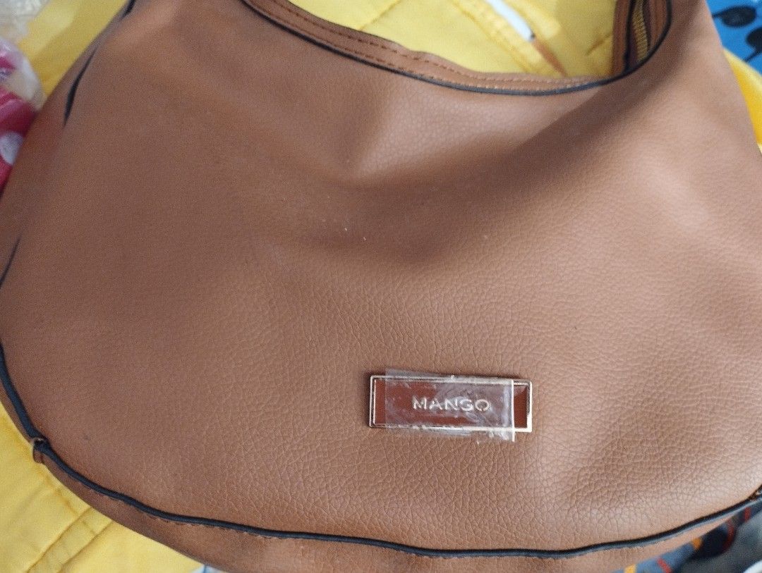 Mango Shoulder Bag Bundle sale with long Kipling wallet (Category: Shoulder Bags) located in Caloocan City. Submitted by myprelovedbutlovedshop (Listing ID 1428503980, Image 1). Description: Mango shoulder bag in a warm brown color. Features a single shoulder strap and a zip closure. The interior is black. The bag has a Mango logo on the front. Includes a tag. If you buy this bag, you'll get a free red Kipling long wallet. Pls note that the freeb