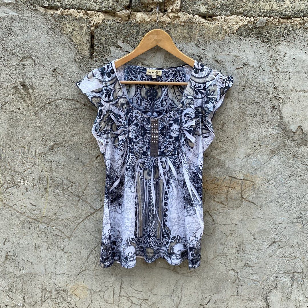 Maralyn & Me Embellished Top (Category: Sleeveless) located in Manila. Submitted by d____g (Listing ID 1428545115, Image 1). Description: Top features a unique print with an embellished design. It has short sleeves and a scoop neckline. The top is hanging on a wooden hanger against a textured wall. The print includes floral and geometric patterns in shades of white, black, and gray..