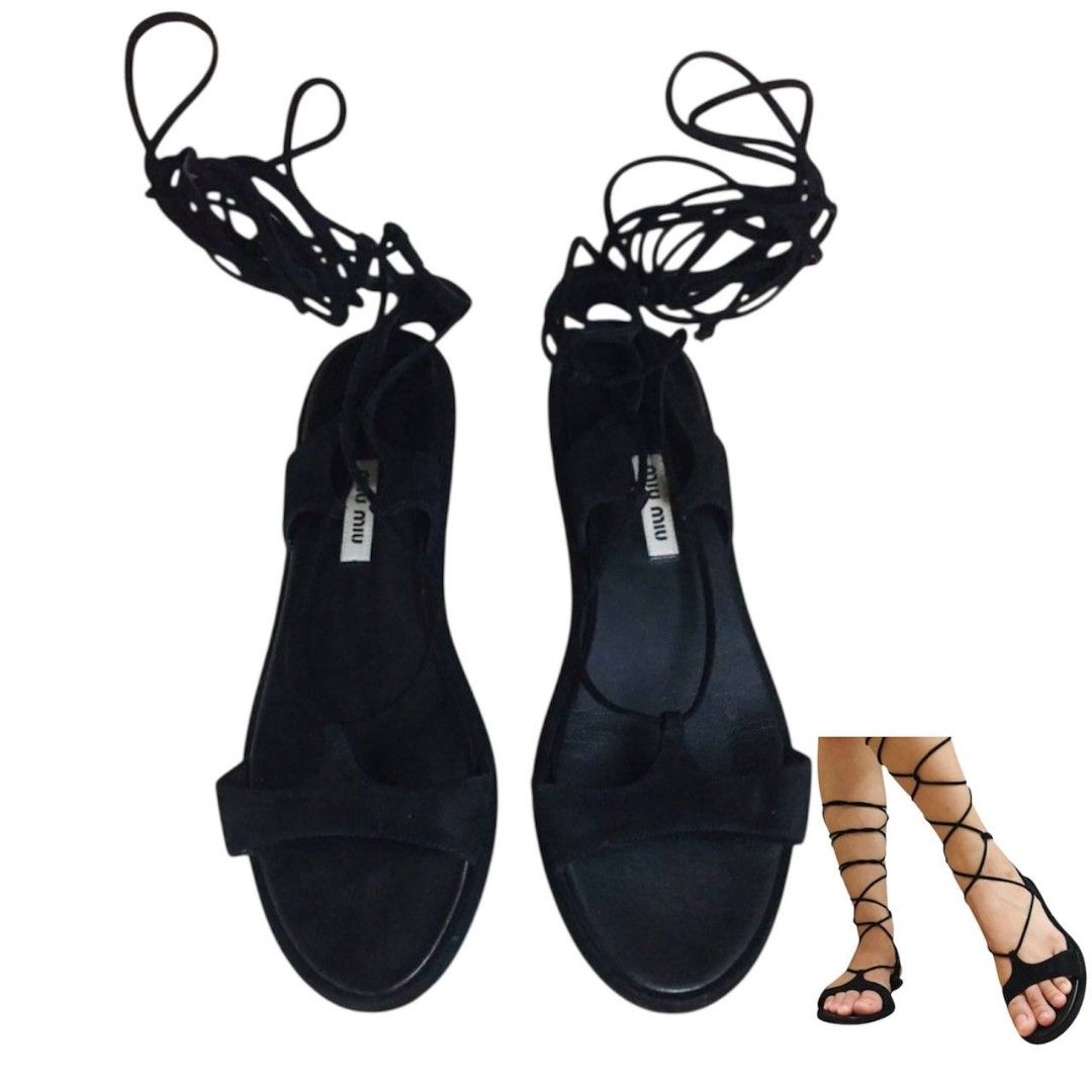 Miu Miu Black Lace-Up Sandals (Category: Sneakers & Footwear) located in Don Carlos. Submitted by satshe (Listing ID 1428439754, Image 1). Description: Elegant black sandals from Miu Miu. Features a lace-up design that wraps around the ankle and a flat sole. The sandals have the Miu Miu logo on the insole. Perfect for adding a touch of sophistication to any outfit. A stylish choice for both casual and dressy occasions..