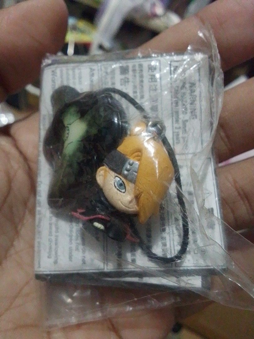 Naruto Deidara Keychain (Category: Character Goods) located in Santa Rosa. Submitted by animemerchcollection (Listing ID 1428552389, Image 1). Description: Deidara keychain from the Naruto anime series. The figure is still in its original packaging. It features Deidara with his signature blonde hair and headband. The keychain has a black string attached for easy carrying. A small piece of paper is visible behind the figure..