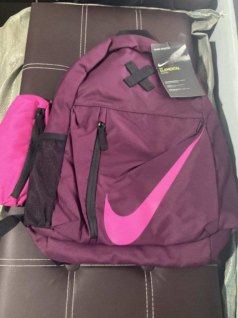 Nike Elemental Backpack (Category: Backpacks) located in Manila. Submitted by epiccloud.3db379 (Listing ID 1428499189, Image 1). Description: Nike Elemental backpack features a vibrant purple color with a large pink Nike swoosh. It has multiple compartments, including a side pocket and a front zippered pocket. The bag has a capacity of 21L. It is designed for young athletes and includes a tag with product details..