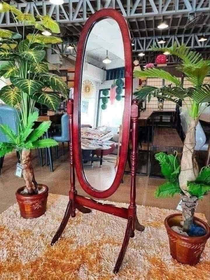 Oval Standing Mirror (Category: Mirrors) located in Manila. Submitted by yzcartph (Listing ID 1428434653, Image 1). Description: Elegant oval-shaped standing mirror with a rich red frame. Features a sturdy wooden stand for stability. Perfect for bedrooms or dressing areas. The mirror provides a full-length view. It is a stylish addition to any space. The frame has a classic design..