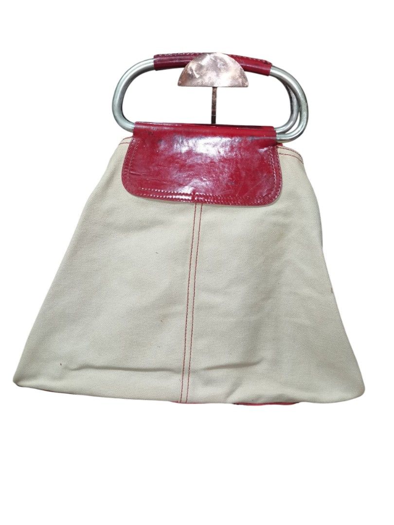 Prada Handbag with Red Accents (Category: Luxury Bags & Wallets) located in Manila. Submitted by eagerbeaverph (Listing ID 1428541343, Image 2). Description: Prada beige canvas metal loop tote bag vintage 2003 rare colorway H 15 inches W 16 D 6 Be a trend-setter with this casual chic Prada Beige Canvas Metal Loop Tote Bag. This bag features durable canvas exterior and nylon interior with metal loop handles. This ultra-spacious tote has the capabi