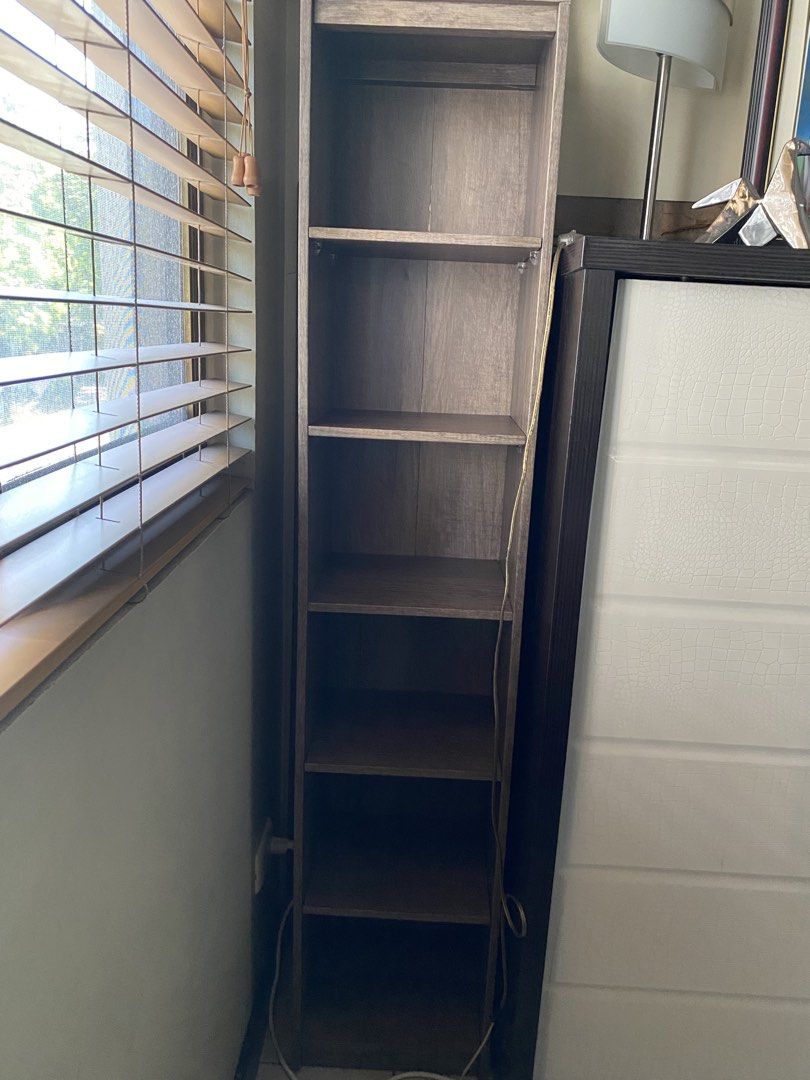 Tall Wooden Bookshelf (Category: Shelves, Cabinets & Racks) located in Makati City. Submitted by rye16 (Listing ID 1428605189, Image 1). Description: Tall, wooden bookshelf with multiple shelves. The bookshelf is tall and narrow, suitable for small spaces. It has six shelves for storage. The bookshelf is standing next to a white wall..