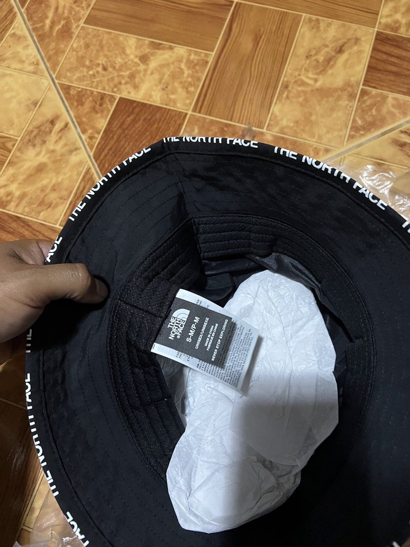 The North Face Bucket Hat (Category: Caps & Hats) located in Binmaley. Submitted by jayvecatalan21 (Listing ID 1428582102, Image 2). Description: Black bucket hat from The North Face. Features the brand's logo on the front and the brand name printed around the brim. Includes original tags and packaging. Size is S-M/P-M. Perfect for sun protection and adding a stylish touch to any outfit..