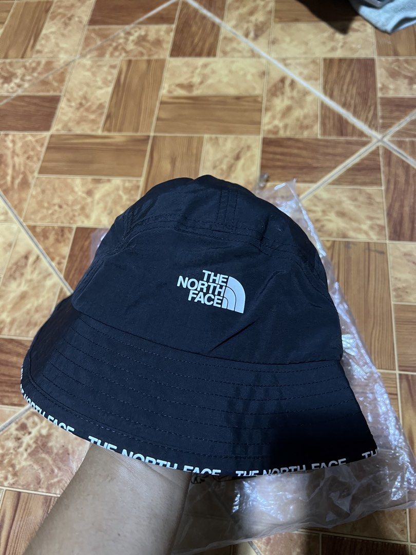 The North Face Bucket Hat (Category: Caps & Hats) located in Binmaley. Submitted by jayvecatalan21 (Listing ID 1428582102, Image 1). Description: Black bucket hat from The North Face. Features the brand's logo on the front and the brand name printed around the brim. Includes original tags and packaging. Size is S-M/P-M. Perfect for sun protection and adding a stylish touch to any outfit..