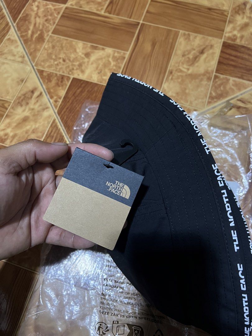 The North Face Bucket Hat (Category: Caps & Hats) located in Binmaley. Submitted by jayvecatalan21 (Listing ID 1428582102, Image 3). Description: Black bucket hat from The North Face. Features the brand's logo on the front and the brand name printed around the brim. Includes original tags and packaging. Size is S-M/P-M. Perfect for sun protection and adding a stylish touch to any outfit..