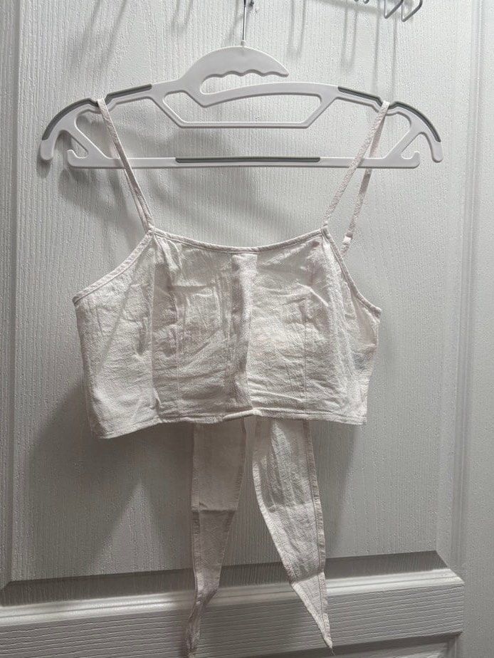 Tie back crop top - white (Category: Sleeveless) located in Makati City. Submitted by declutterwithmeeeee (Listing ID 1428597388, Image 1). Description: long straps at the hem that can be tied into a beautiful ribbon bow in the back. Summer | beach wear | casual wear.