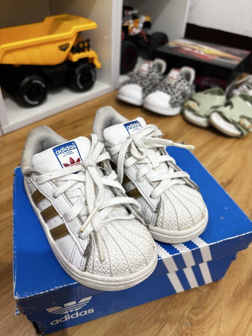 Adidas Superstar Toddler Shoes (Category: Babies & Kids Fashion) located in Valenzuela. Submitted by cmdgbaby (Listing ID 1428714568, Image 2). Description: 💎 AUTHENTIC ADIDAS SUPERSTAR TODDLER SNEAKERS 💎 • Size: US 7K (perfect for little ones aged ~1–3 years) • Colorway: Classic White with Metallic Gold Stripes • Condition: Gently used – still in great shape with minor signs of wear (nothing that affects style or function!) just needs cleanind