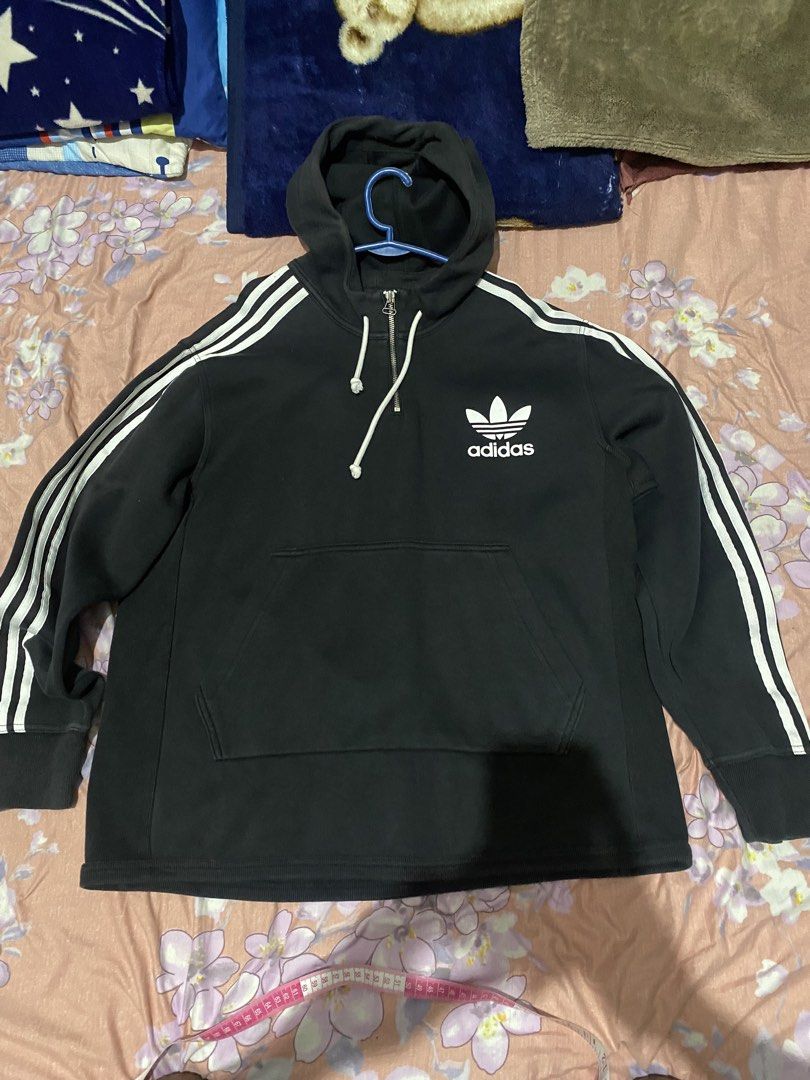 Adidas Terry Hooded Sweatshirt (Category: Coats, Jackets and Outerwear) located in Batangas. Submitted by aidenbotchog (Listing ID 1428626904, Image 1). Description: Black Adidas hoodie with white stripes on the sleeves and a front pocket. Features a half-zip closure and the Adidas logo on the chest. The tag indicates the size is L. Made with a blend of cotton and polyester. The hoodie has a hood with drawstrings L28W23.