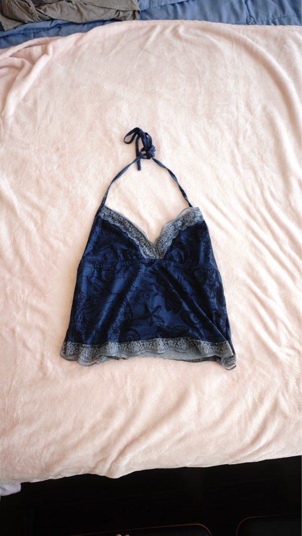 Blue Halter Top with Lace Trim (Category: Sleeveless) located in Manila. Submitted by rayennss (Listing ID 1428695519, Image 1). Description: Blue halter top features a delicate lace trim along the neckline and hem. It has a tie closure at the neck. The top is made of a silky material and has a floral pattern. It is a stylish piece that can be paired with jeans or skirts..