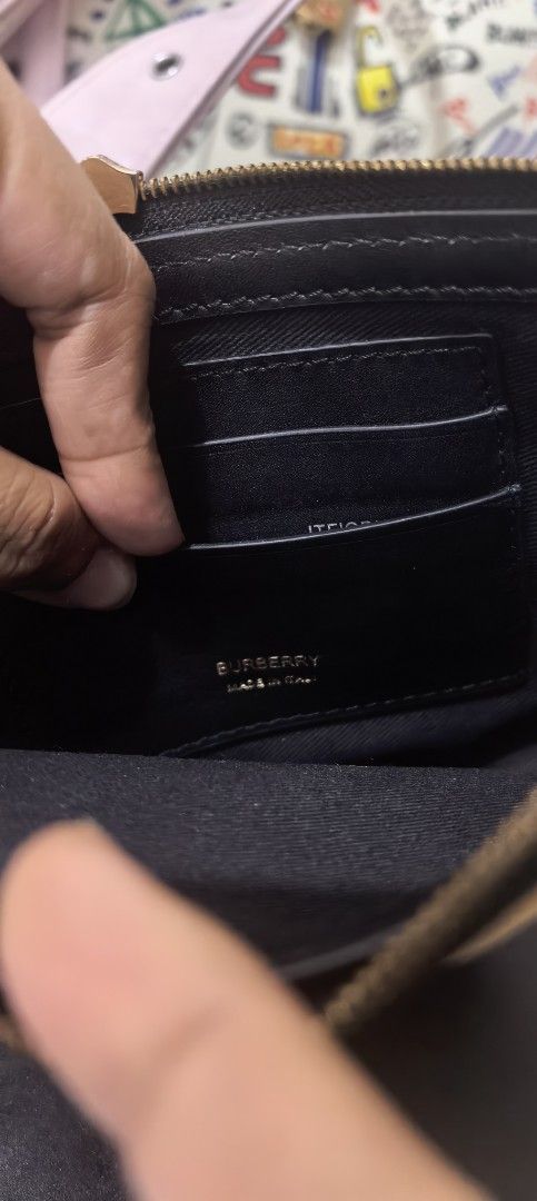 Burberry Checkered Shoulder Bag (Category: Luxury Bags & Wallets) located in Cagayan de Oro. Submitted by tommygurl1218 (Listing ID 1428649840, Image 2). Description: Burberry shoulder bag features the iconic checkered pattern. It has a black leather strap and gold-toned hardware. The interior includes multiple card slots and a zipper closure. The bag is marked "Burberry" and "Made in Italy". With code. Minimal. Sign of use. .