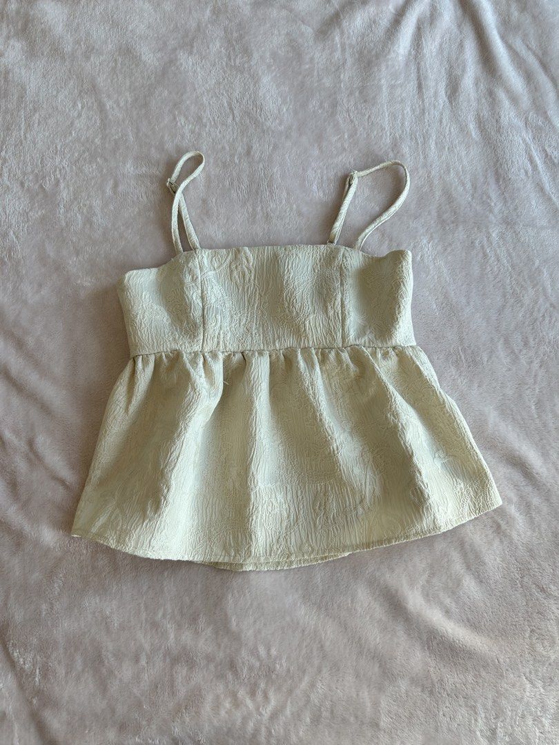 Cream-colored Cami Top (Category: Sleeveless) located in Manila. Submitted by rayennss (Listing ID 1428694518, Image 1). Description: Cream-colored cami top features a square neckline and adjustable straps. It has a textured fabric and a peplum-style hem. The top is suitable for casual wear and can be paired with jeans or skirts. It is a versatile piece for your wardrobe..