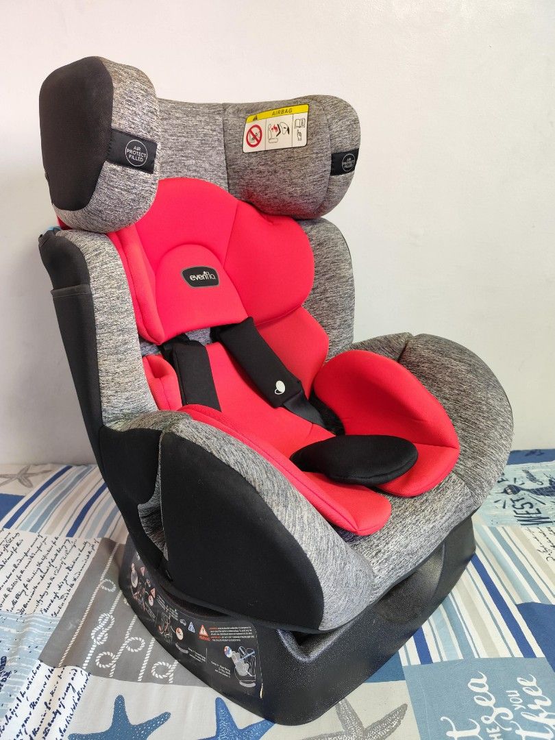 Evenflo Car Seat (Category: Car Seats) located in Bacoor. Submitted by acm.cm (Listing ID 1428745643, Image 3). Description: Evenflo car seat features a red and gray design. It has a headrest and adjustable straps for safety. The seat is designed for different weight groups, as indicated on the labels. It includes an airbag warning and instructions for proper installation..