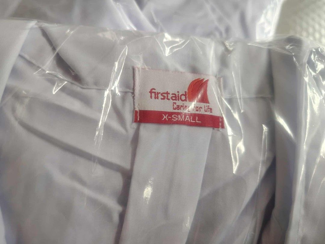 Firstaid Lab Coat - X-Small and Small (Category: Other Assistive Aids) located in Manila. Submitted by marino06 (Listing ID 1428702124, Image 1). Description: White lab coats from Firstaid. Available in X-Small and Small sizes. Each coat is individually packaged in plastic. The coats have a red label with the Firstaid logo and the words "Caring for Life"..