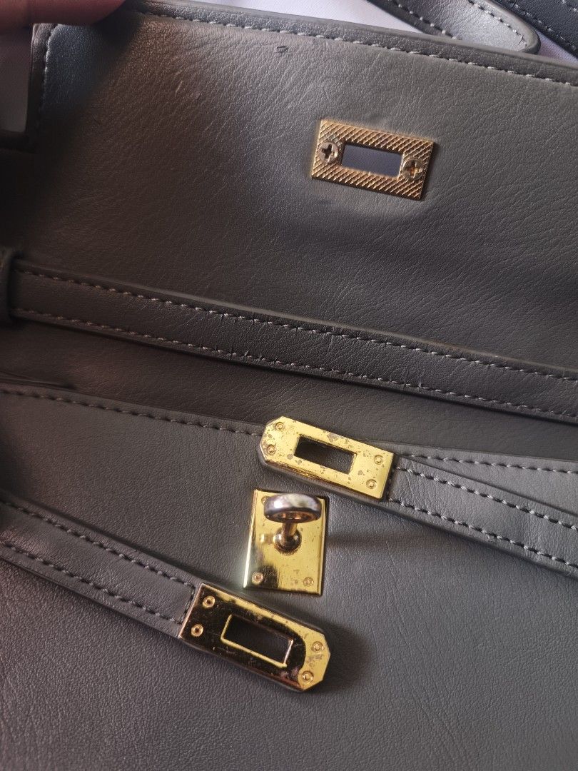 Grey Crossbody Bag with Gold Hardware (Category: Luxury Bags & Wallets) located in Bacoor. Submitted by nia.niya015 (Listing ID 1428736448, Image 3). Description: Strap length - 22 inches Depth - 3 inches Width - 9.5inches Height - 7 inches -has flaws but barely noticeable -gold hardware is slightly fading -may bakbak sa straps Grey crossbody bag features a rectangular shape with a flap closure and gold-colored hardware. The bag has a long, adjus
