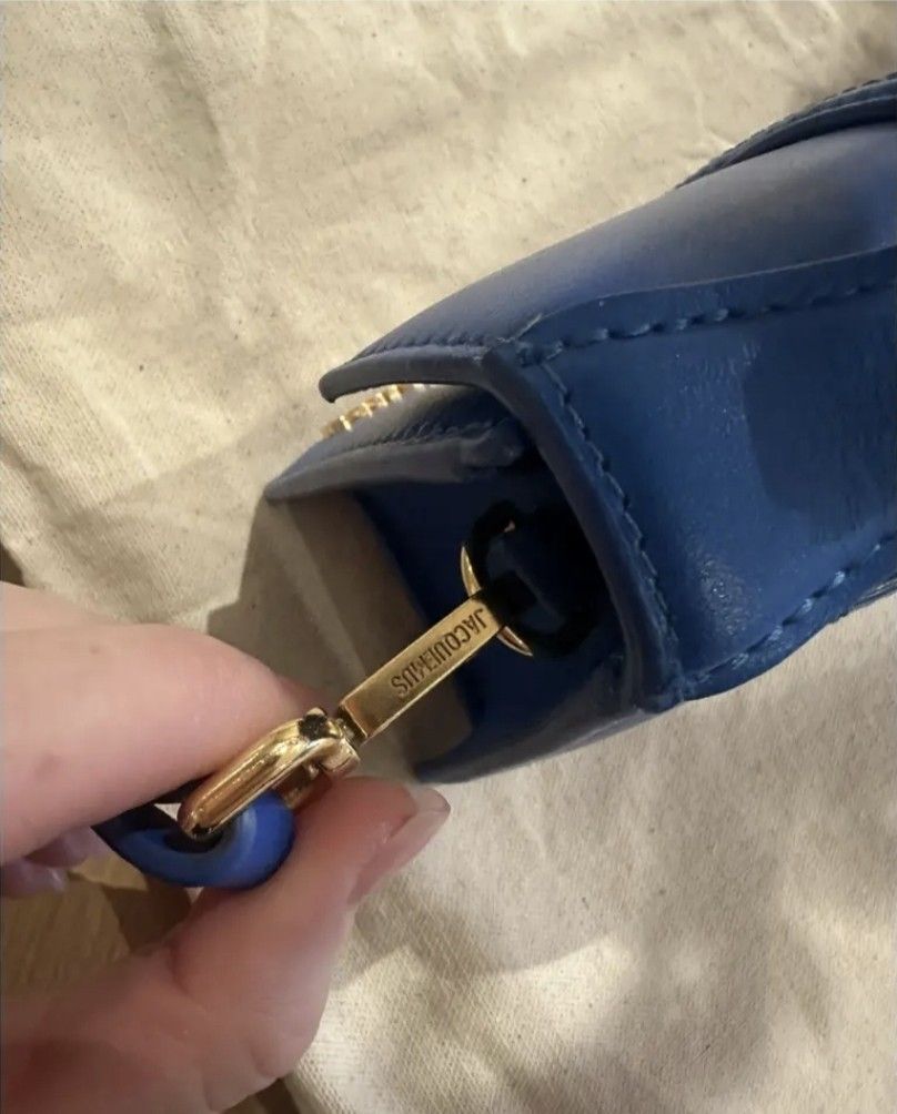 Jacquemus Le Bambino Bag - Blue (Category: Luxury Bags & Wallets) located in Manila. Submitted by bellissima05 (Listing ID 1428731042, Image 3). Description: Vibrant blue Jacquemus Le Bambino handbag. Features a structured rectangular shape with a flap closure and a top handle. The bag has a prominent front flap with a stitched detail and the brand's logo in gold lettering. Includes a detachable shoulder strap. Product information Brand: Jacquemu