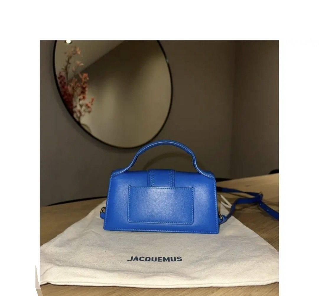 Jacquemus Le Bambino Bag - Blue (Category: Luxury Bags & Wallets) located in Manila. Submitted by bellissima05 (Listing ID 1428731042, Image 2). Description: Vibrant blue Jacquemus Le Bambino handbag. Features a structured rectangular shape with a flap closure and a top handle. The bag has a prominent front flap with a stitched detail and the brand's logo in gold lettering. Includes a detachable shoulder strap. Product information Brand: Jacquemu