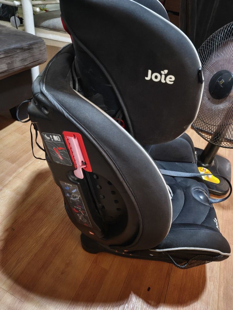 Joie Car Seat (Category: Car Seats) located in Paranaque City. Submitted by judy.arquillos (Listing ID 1428651509, Image 2). Description: Black Joie car seat. Features include a headrest, shoulder pads, and a five-point harness. The seat has side impact protection and is suitable for children from 0-18kg. The seat has a red adjustment lever and a label indicating the correct installation. The seat has a Joie logo. 2000+SHIP J&T LALAMOVE PICK-UP.