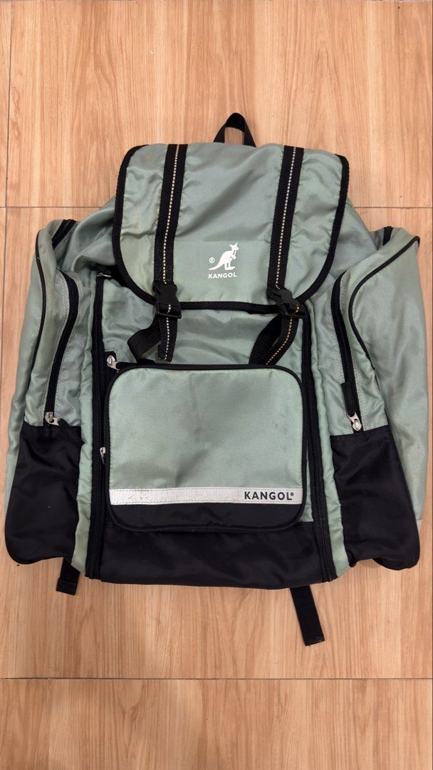 Kangol Backpack (Category: Backpacks) located in Alfonso. Submitted by jbcamet (Listing ID 1428717565, Image 1). Description: Kangol backpack features a light green and black color scheme. It has multiple compartments, including side pockets and a front pocket. The backpack has adjustable straps and a top handle. The main compartment has a drawstring closure. The Kangol logo is visible on the front..