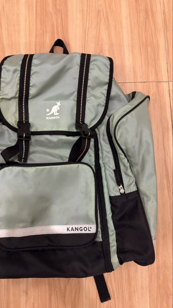 Kangol Backpack (Category: Backpacks) located in Alfonso. Submitted by jbcamet (Listing ID 1428717565, Image 2). Description: Kangol backpack features a light green and black color scheme. It has multiple compartments, including side pockets and a front pocket. The backpack has adjustable straps and a top handle. The main compartment has a drawstring closure. The Kangol logo is visible on the front..