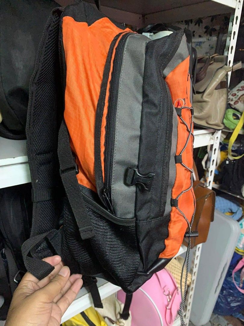 Leisure Treksta Backpack (Category: Backpacks) located in Santo Tomas. Submitted by jadelyoidd53654 (Listing ID 1428649116, Image 2). Description: Backpack features a vibrant orange and black color scheme. It has multiple compartments, including side pockets and a front bungee cord system. The backpack also includes a rain cover. The brand name "Leisure Treksta" is visible on the bag..