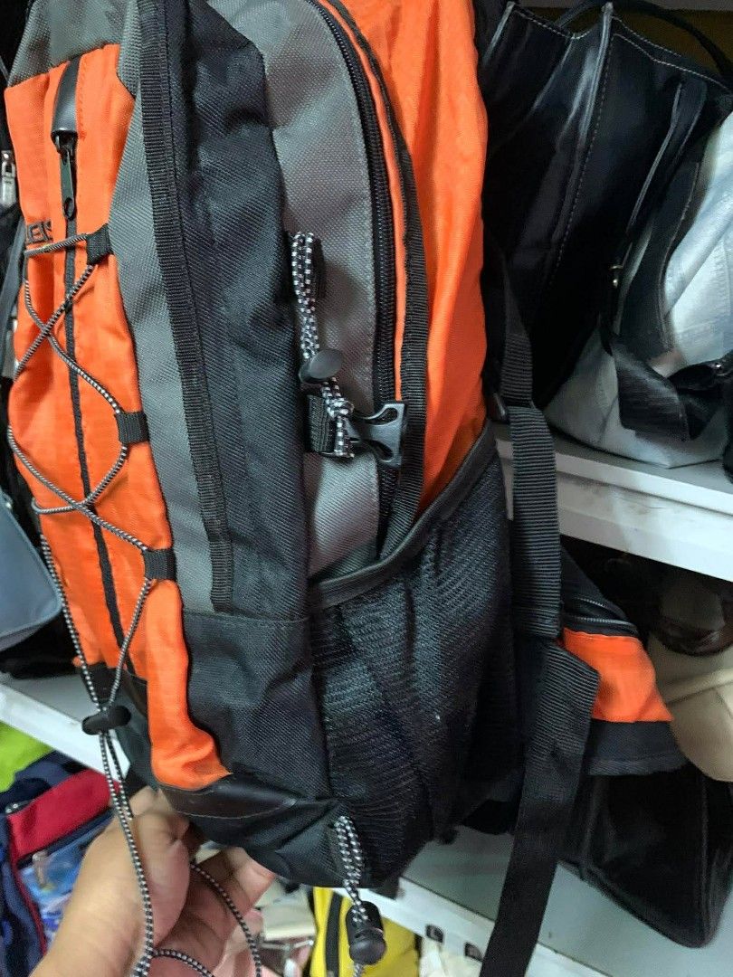 Leisure Treksta Backpack (Category: Backpacks) located in Santo Tomas. Submitted by jadelyoidd53654 (Listing ID 1428649116, Image 3). Description: Backpack features a vibrant orange and black color scheme. It has multiple compartments, including side pockets and a front bungee cord system. The backpack also includes a rain cover. The brand name "Leisure Treksta" is visible on the bag..