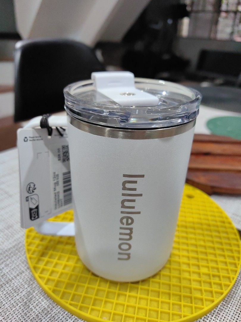Lululemon Insulated Mug 12oz (Category: Coffee & Tea Tableware) located in Quezon City. Submitted by flat.earther23 (Listing ID 1428612140, Image 1). Description: Lululemon insulated mug is 12oz and comes with a lid. It is white and has a handle. The mug has the Lululemon logo printed on the side. The original tag is still attached. It is designed to keep your drinks cold or hot..