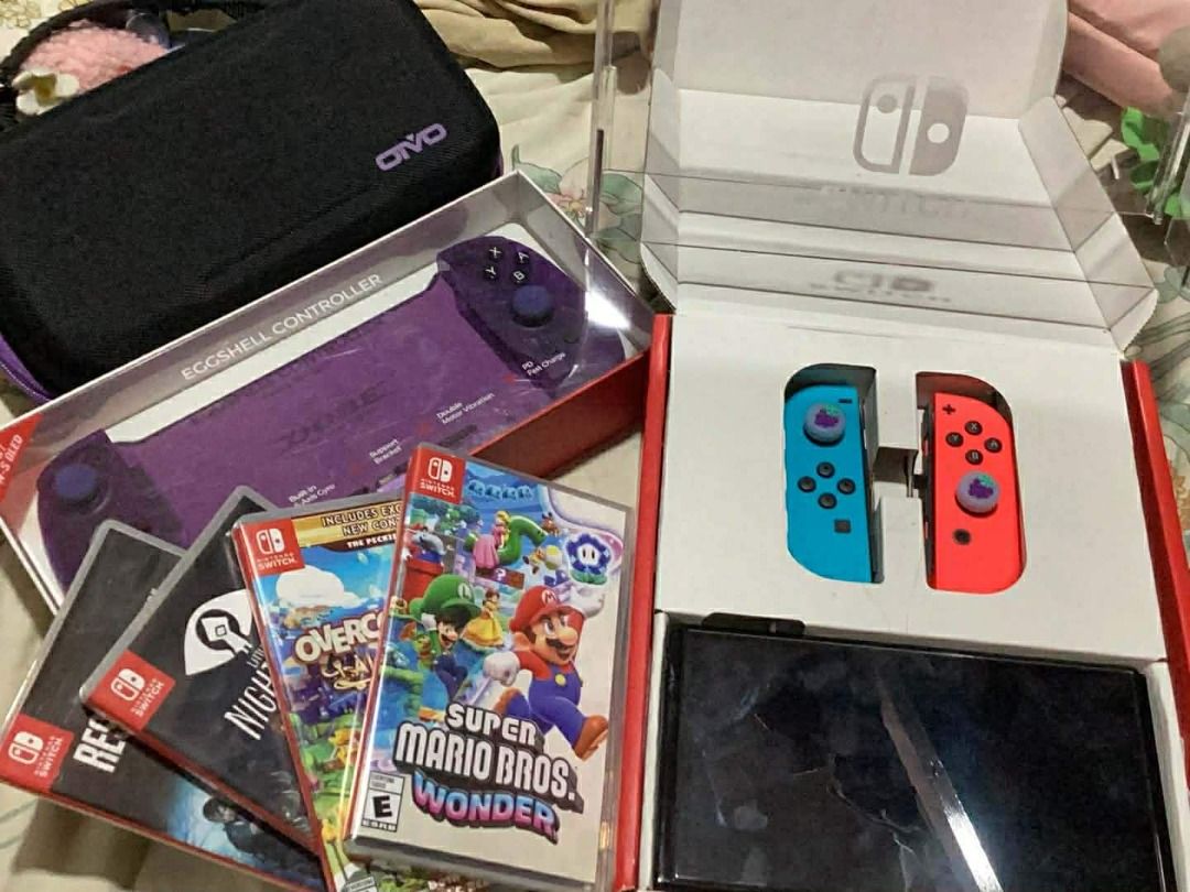 NINTENDO SWITCH OLED SLIGHTLY USED (Category: Nintendo) located in Caloocan City. Submitted by freefish.3b9e0a (Listing ID 1428613696, Image 2). Description: LIGHTLY USED, 3 years Old COMPLETE SET W/BOX AND ALL THE ACCESSORIES. Nintendo Switch Console With Red/Blue Joycon (OLED Model) Standalone ACCESSORIES: Nintendo Switch Bag (pink & gray) Dobe Eggshell Controller for Switch/Switch OLED (Transparent Purple) NSW OIVO Carry Case FOR N-Switch / N-