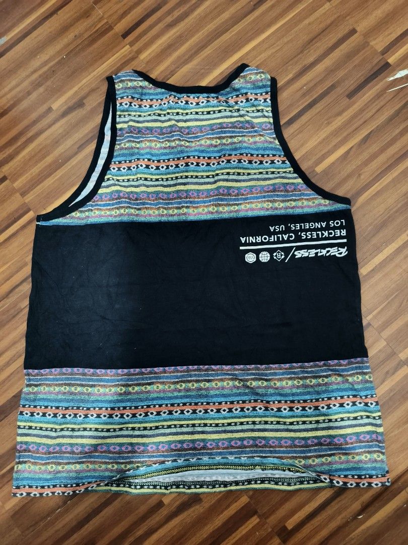 Reckless Los Angeles Tank Top (Category: Sleeveless) located in Manila. Submitted by nmictbon40960 (Listing ID 1428718140, Image 2). Description: Stylish Reckless Los Angeles tank top. Features a black panel with the brand's logo and the words "Los Angeles". The top has a colorful tribal pattern on the upper and lower sections. The back of the tank top also has the brand's logo and the words "Reckless, California, Los Angeles, USA"..