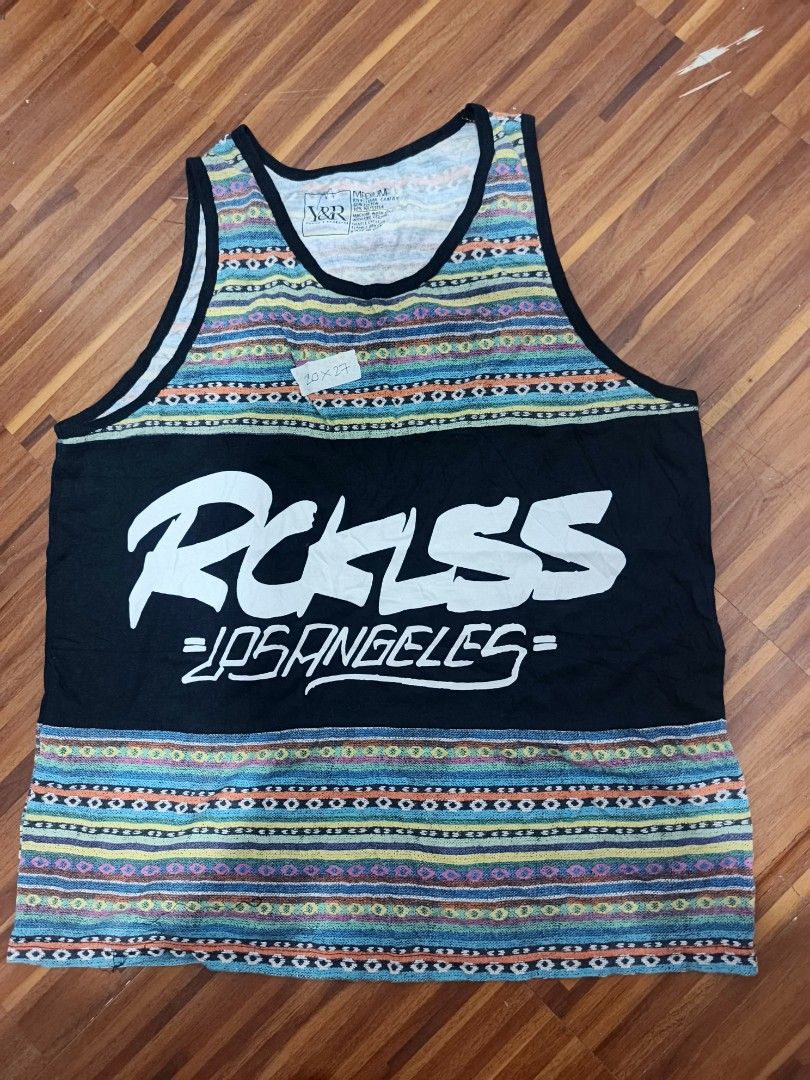 Reckless Los Angeles Tank Top (Category: Sleeveless) located in Manila. Submitted by nmictbon40960 (Listing ID 1428718140, Image 1). Description: Stylish Reckless Los Angeles tank top. Features a black panel with the brand's logo and the words "Los Angeles". The top has a colorful tribal pattern on the upper and lower sections. The back of the tank top also has the brand's logo and the words "Reckless, California, Los Angeles, USA"..